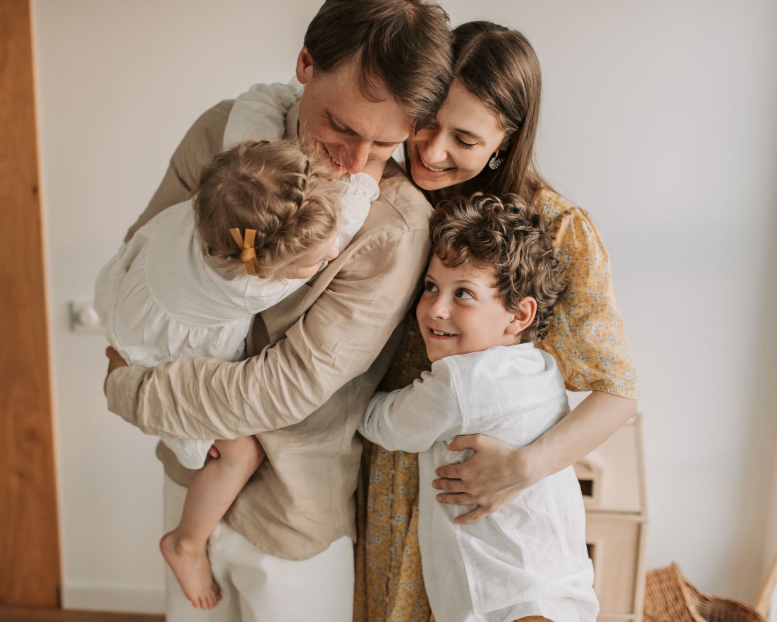 Parents serrant leurs deux enfants dans leurs bras — La Centrale des Assurances